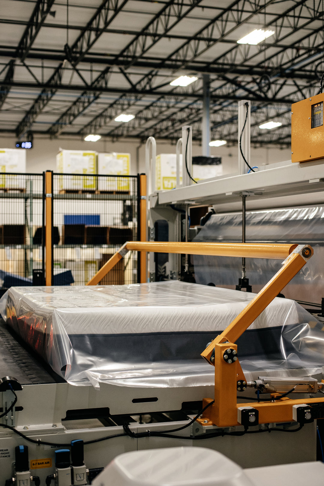 Photo of a Comfort Option mattress on a mattress rolling machine.