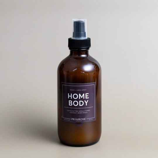 A bottle of Primrose Home Body room spray against a grey background