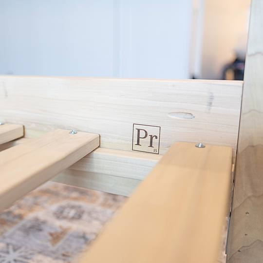 Wooden bench with a 'Pr' logo on a blurred background