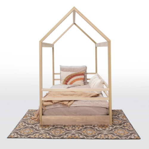 Wooden children's bed with bedding on a patterned rug