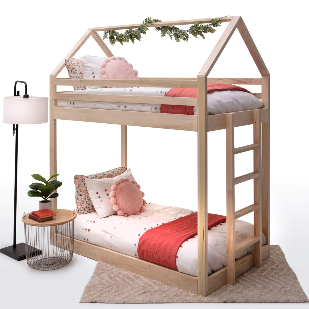 Wooden children's bunk bed with bedding and decor on a white background