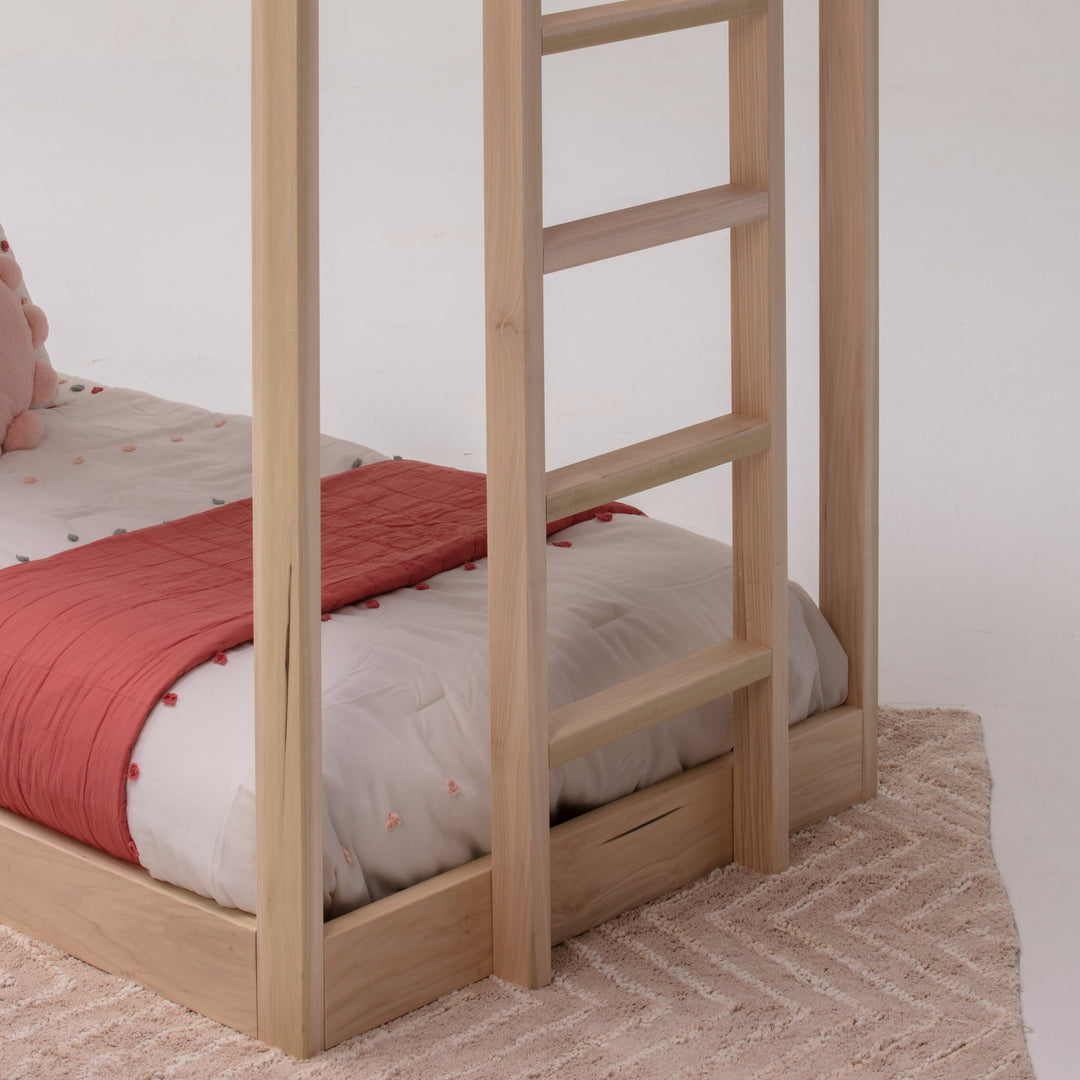 Wooden bunk bed with red and white bedding on a plain background