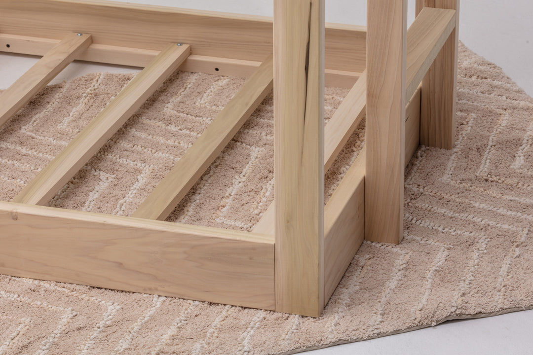 Wooden bed frame on a textured carpet