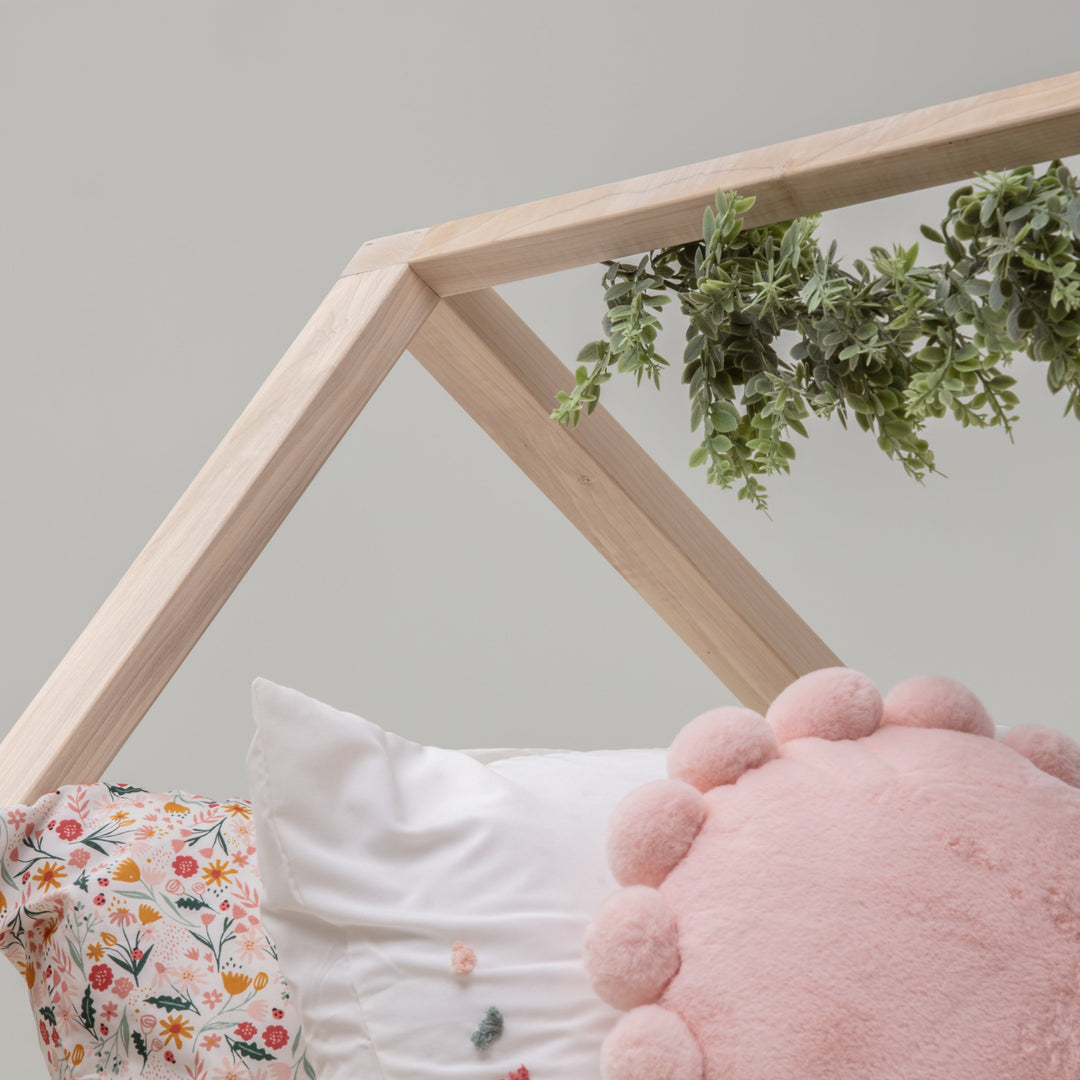 Wooden crib with greenery and a baby's foot peeking out