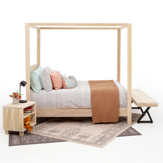 Wooden canopy bed with bedding and a nightstand in a minimalistic room.