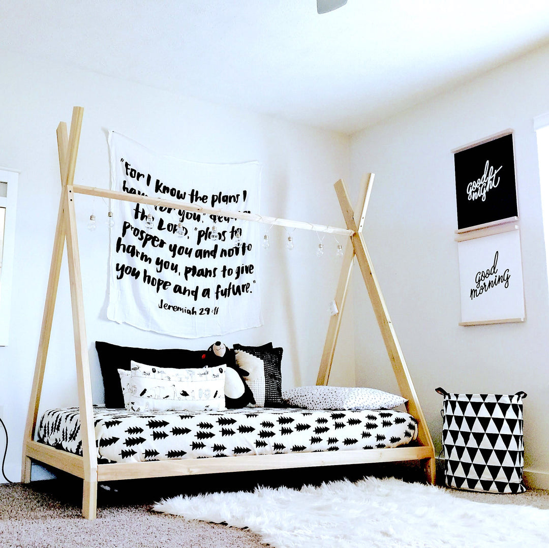 Children's bedroom with a teepee bed, wall tapestry, and decorative items.