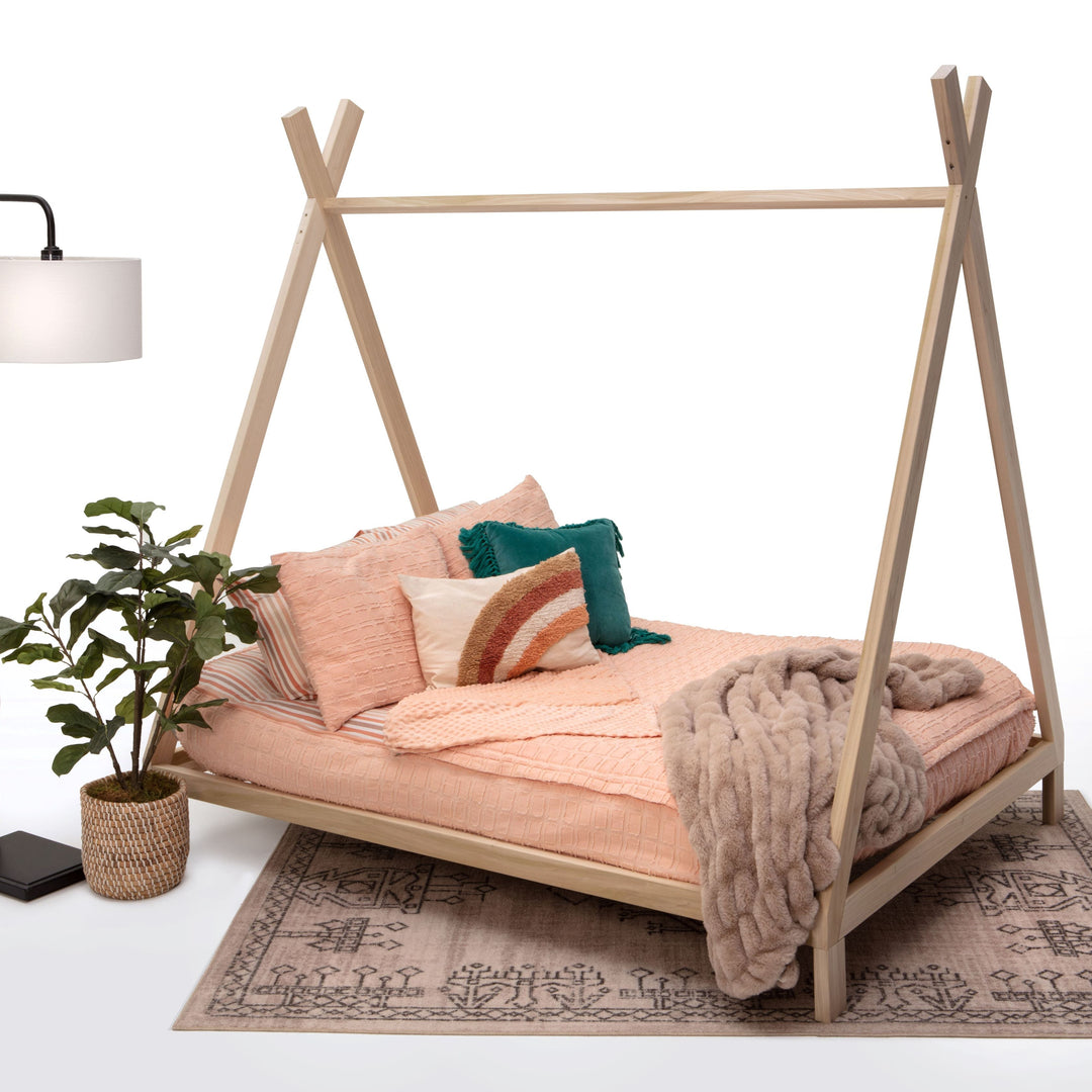 Wooden teepee-style bed with bedding and decor on a white background