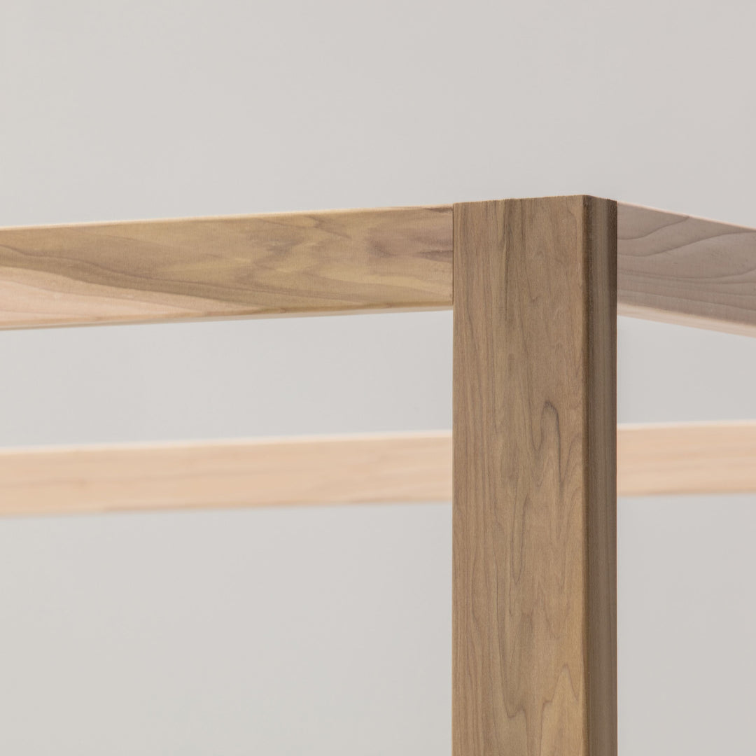Close-up of a wooden table corner with a light gray background