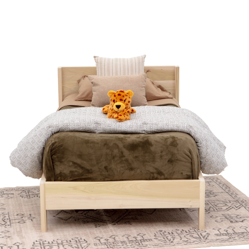 Wooden bed with bedding and a teddy bear on a white background