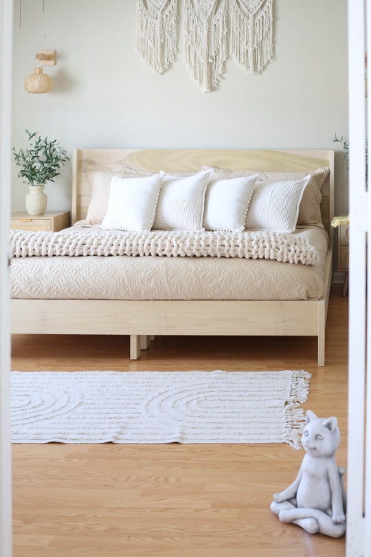 Bedroom with a wooden bed, white pillows, and decorative elements.