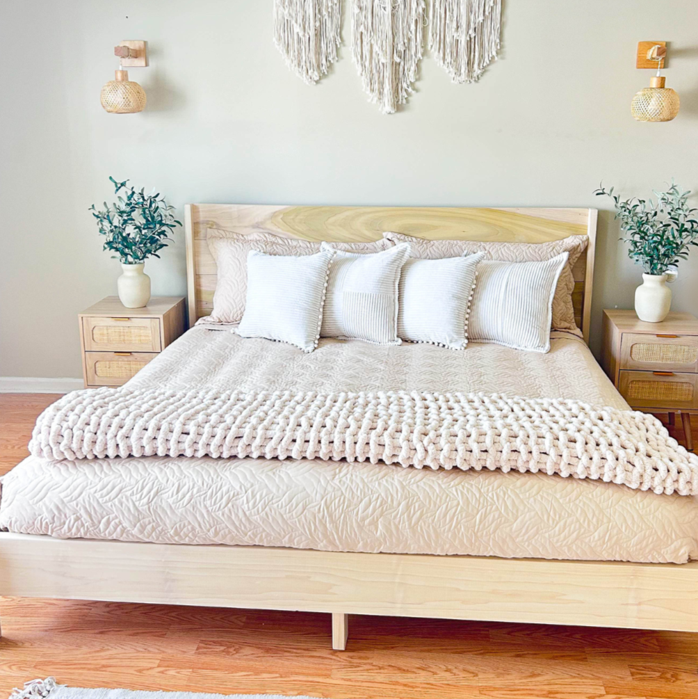 Neatly made bed with white bedding in a bedroom setting.