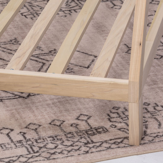 Wooden bed frame on a patterned rug
