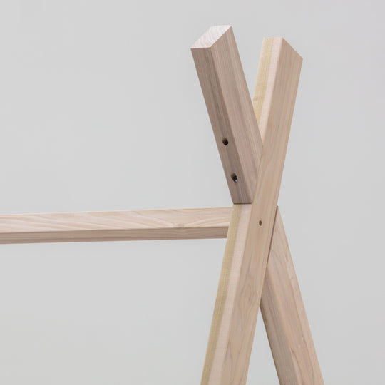 Wooden shelf structure against a plain background